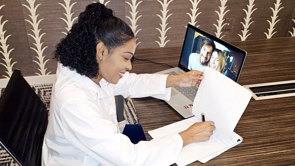 Anah Williams-Martin taking notes during a telehealth consultation
